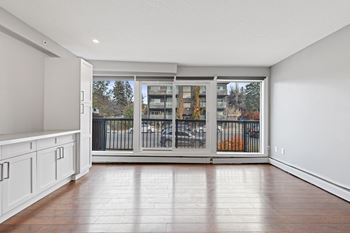 A room with a sliding glass door leading to a balcony.